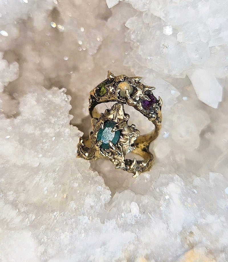 Gold ring with gemstones on a white crystal background, chalcedony ring, peridot ring