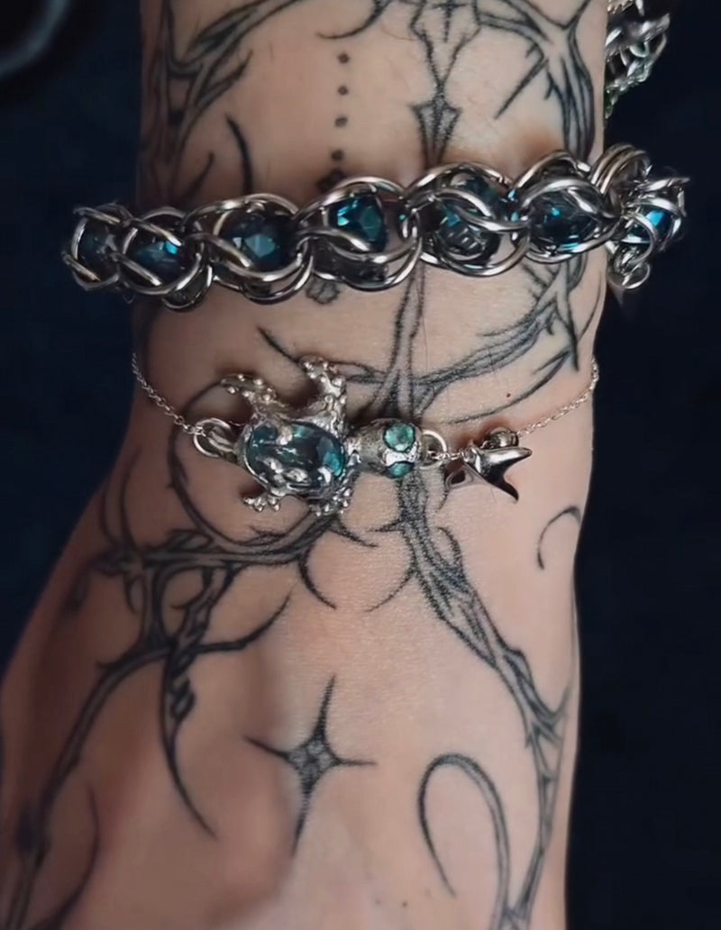Silver bracelets with a blue apatite gemstones on a tattooed arm