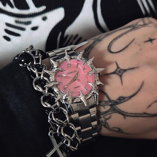 Bracelet with pink star-shaped charm on a tattooed wrist against a black and white background